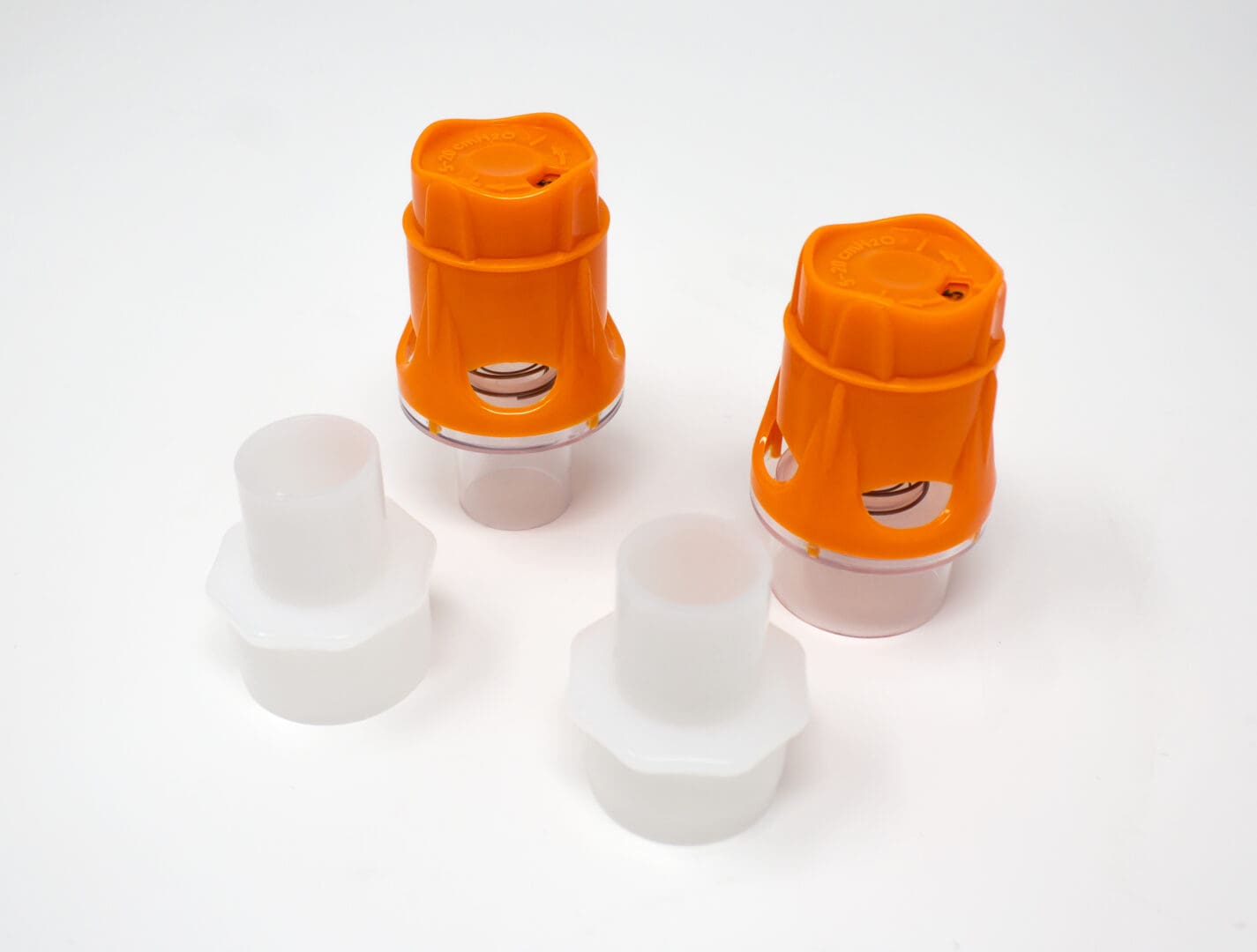 Two Koo stepPEEP valves with orange caps and white adapters