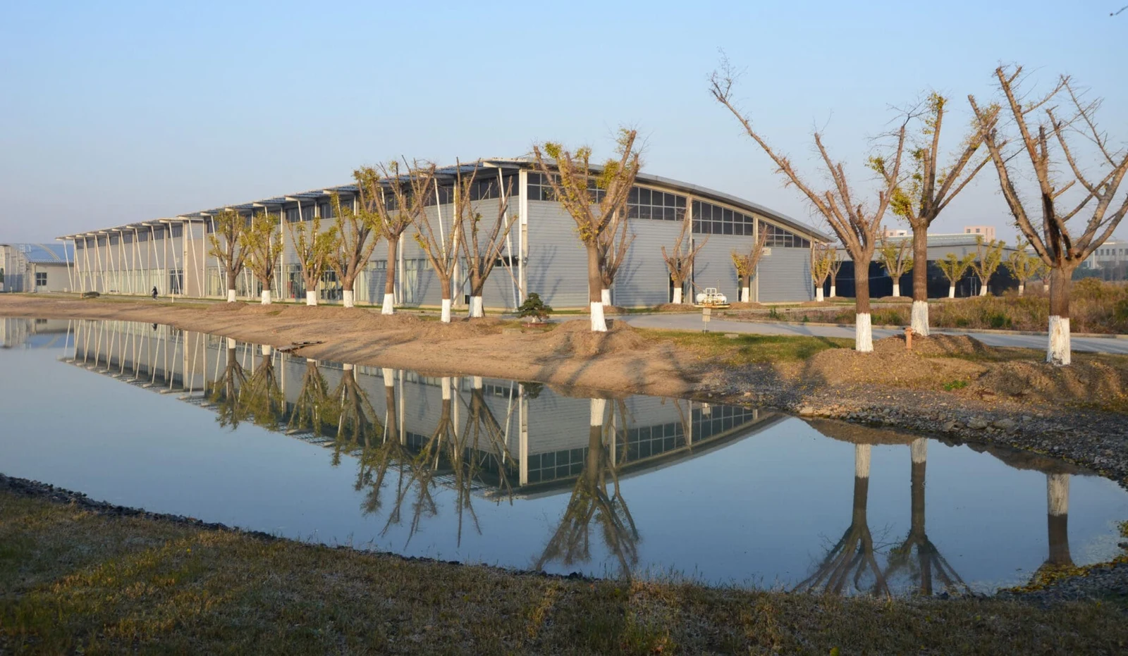 Koo manufacturing campus in Shanghai, reflected in the adjacent pond